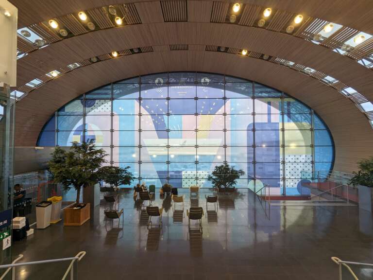 Une fresque colorée habille l'immense baie vitrée d’un hall d’embarquement.
