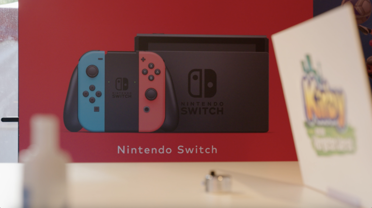Gros plan sur une affiche Nintendo Switch présentant la console et ses manettes Joy-Con rouge et bleue.